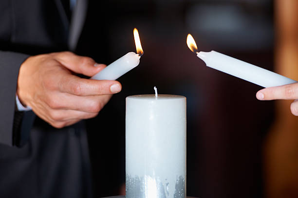 closeup shot of a couple lighting candles during their wedding ceremony